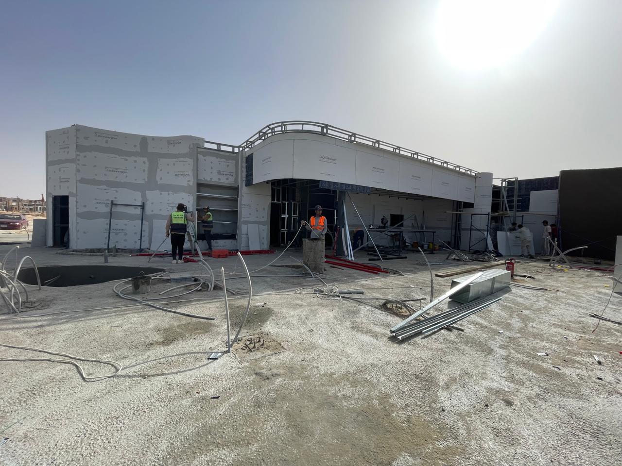 Eng. Emad Wagdy on site reviewing structural drawings with his team.
